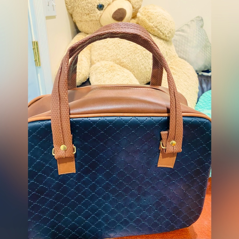 stylish black travel bag with brown handles